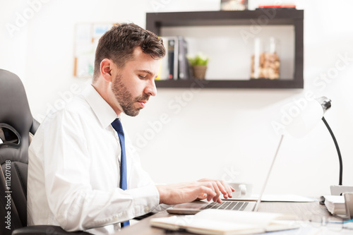 Busy businessman typing on a laptop