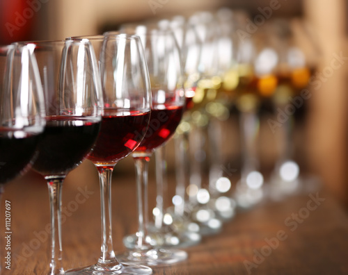 Many glasses of different wine in a row on bar counter