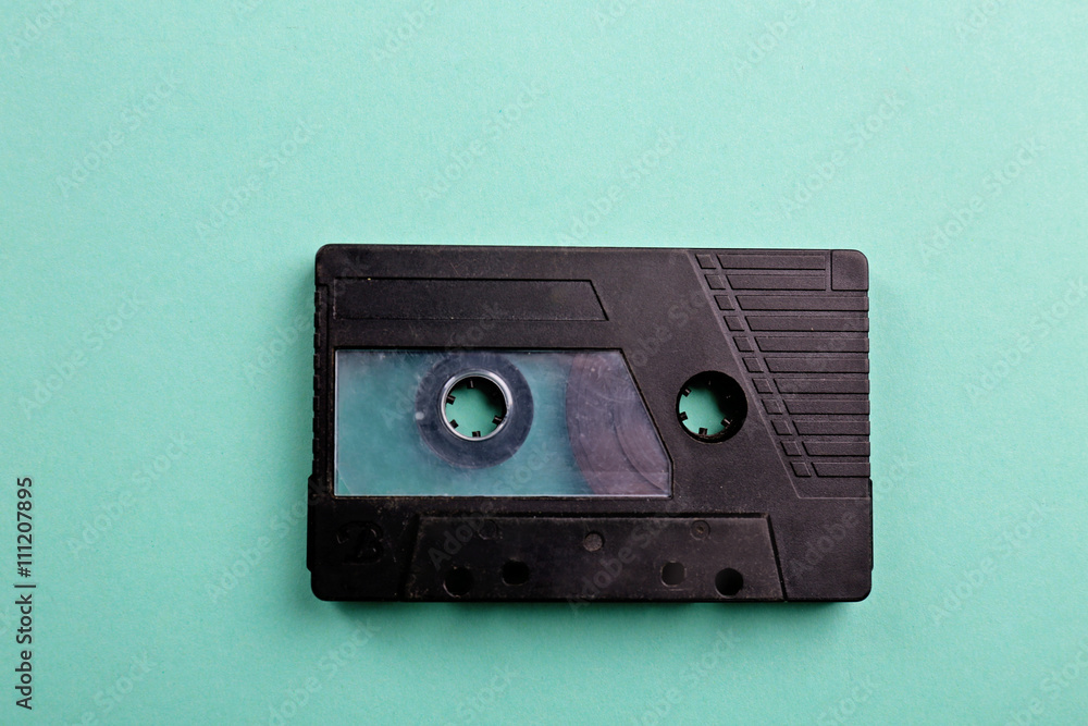Fototapeta premium Old audio cassette on turquoise background