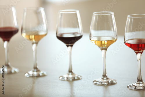 Many glasses of different wine in a row on a table