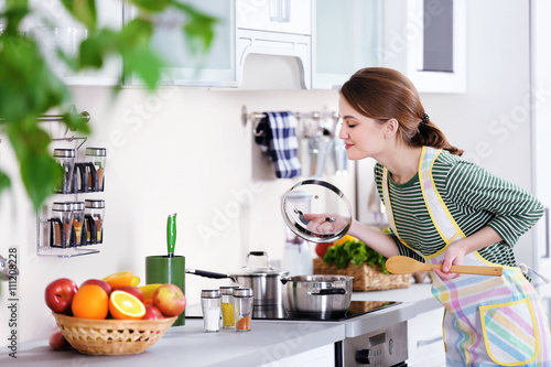 Young woman cooking in the ...