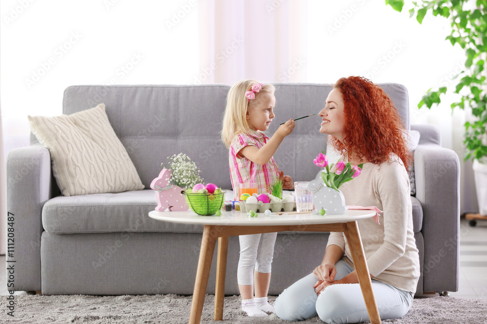 Mother and daughter decorating Easter eggs, indoors Mother and daughter decorating Easter eggs, indoors