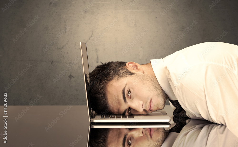Obraz premium Frustrated businessman's head on keyboard