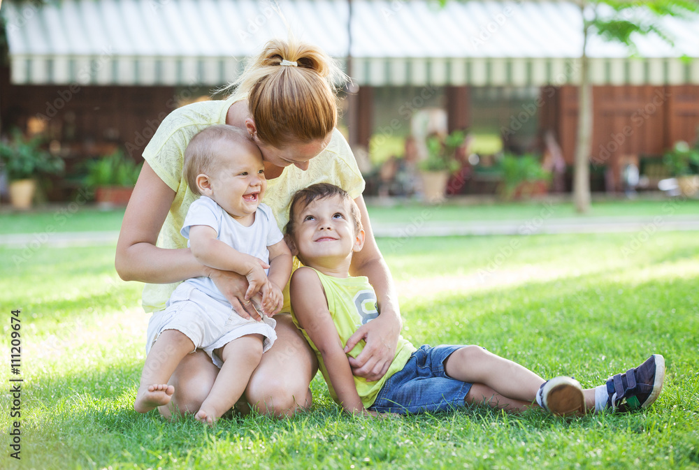 Young mother and two sons enjoying beautiful day in park Young mother and two sons enjoying beautiful day in park