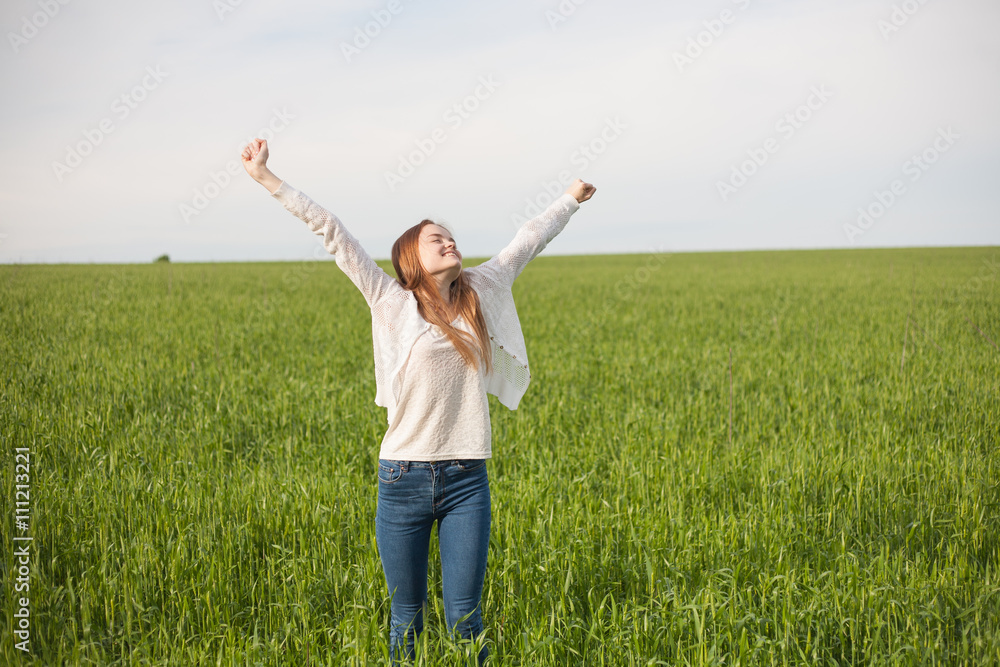 woman with open arms in the green wheat field at the morning woman with open arms in the green wheat field at the morning