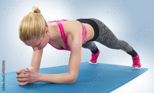 Athlete girl doing plank exercise.
