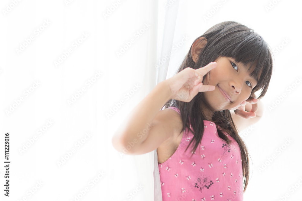 Happy Asian girl holding white curtain at home with copy space. Happy Asian girl holding white curtain at home with copy space.