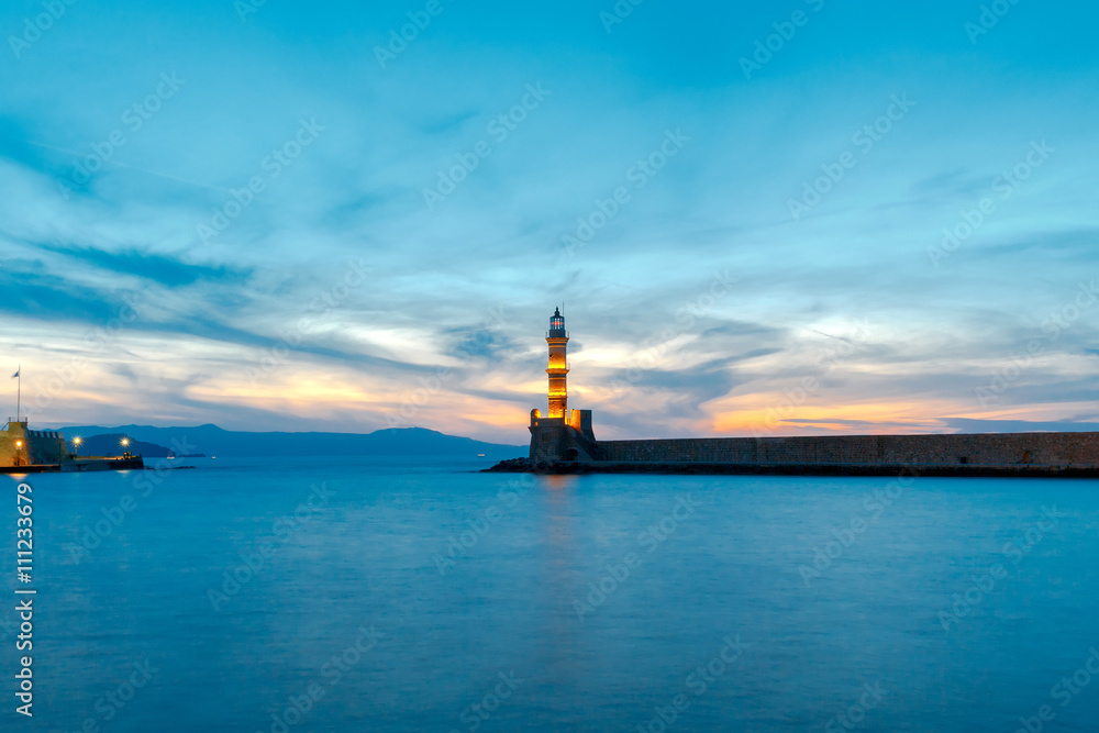 Chania. Lighthouse in the old harbor at night.