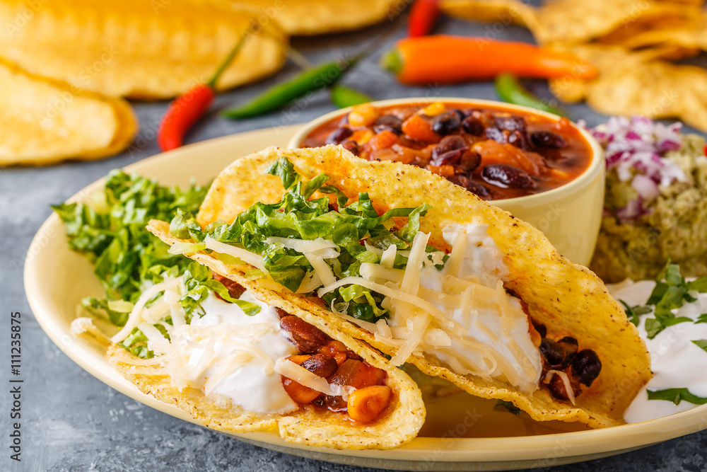 Tacos with chili con carne, salad, cheese and sour cream. Tacos with chili con carne, salad, cheese and sour cream.