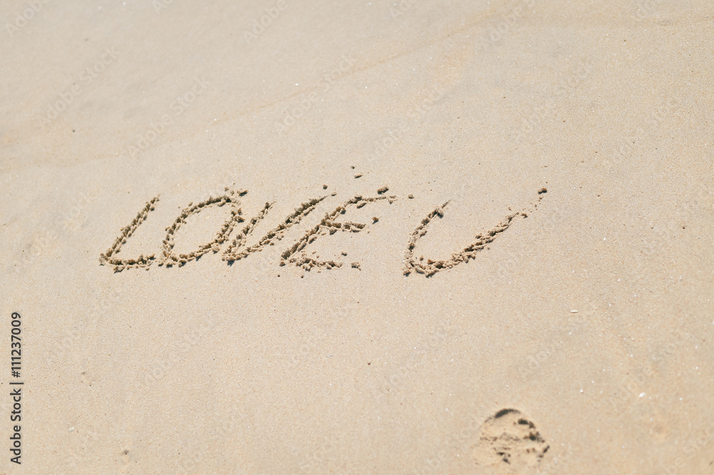 Fototapeta premium Love U sign on the sand beach copy space background texture