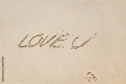 Love U sign on the sand beach copy space background texture