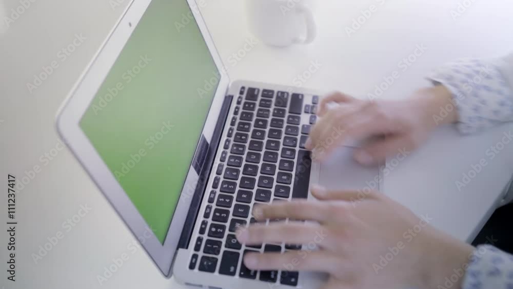 Young caucasian woman in her 30s using her laptop with a green screen to insert new content Young caucasian woman in her 30s using her laptop with a green screen to insert new content