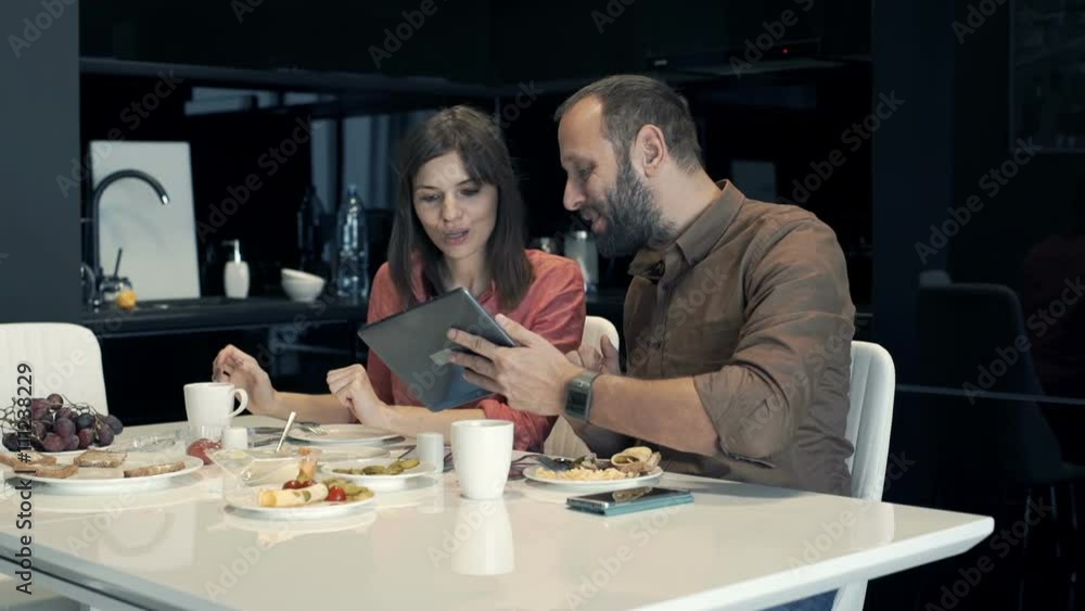 Young couple with tablet talking during breakfast in kitchen at home
Young couple with tablet talking during breakfast in kitchen at home