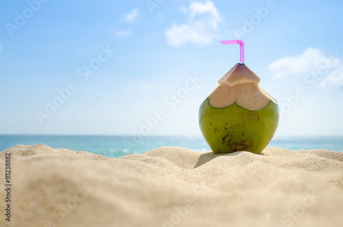 Coconut drink on sand beach.