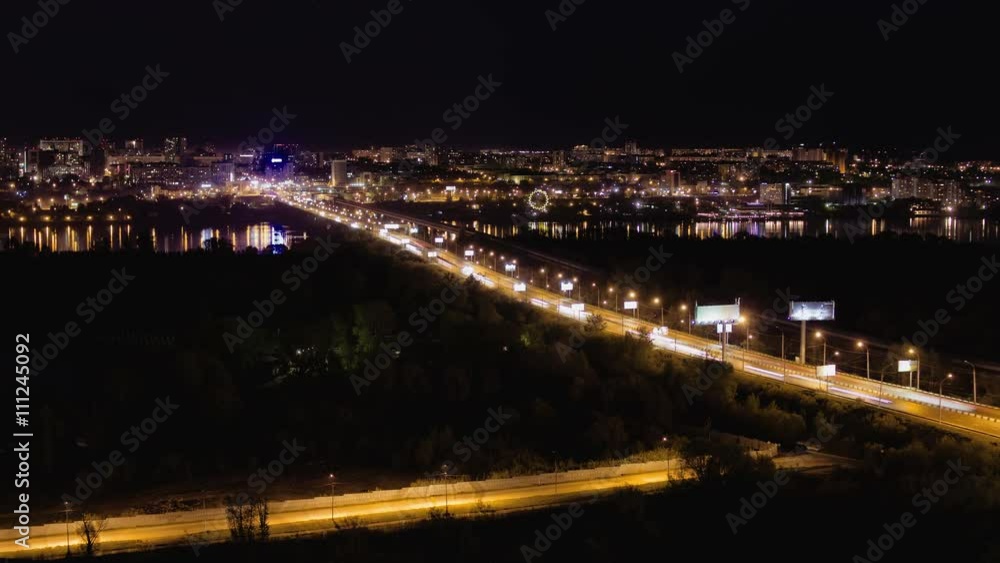 Time lapse of busy night traffic on the bridge, against the backdrop of the city Time lapse of busy night traffic on the bridge, against the backdrop of the city