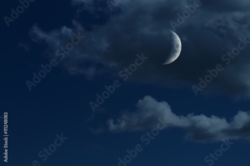 young growing moon in night sky with clouds, no stars