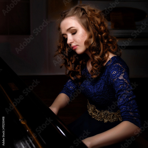 Young woman playing the grand piano