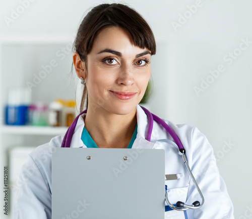 Beautiful smiling female doctor hold and hug clipboard pad