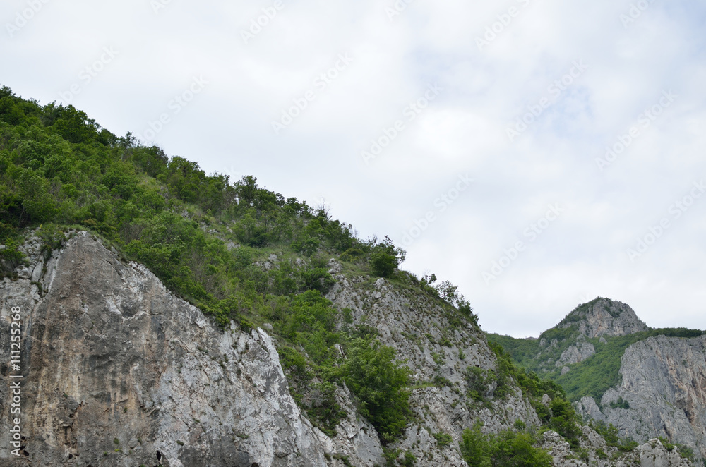 Cliffs with rare overgrowth under cloudy sky