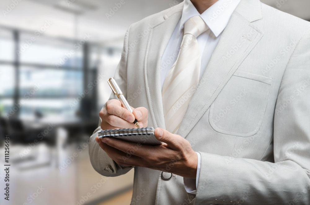 man in a suit with a notebook