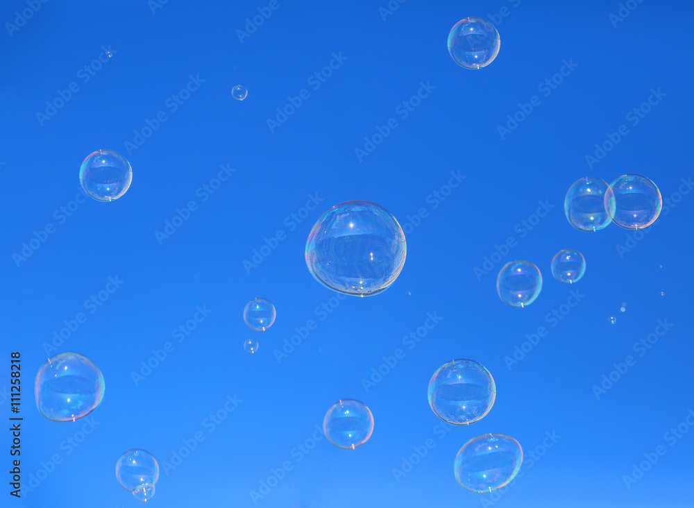 Soap bubbles floating in a blue sky