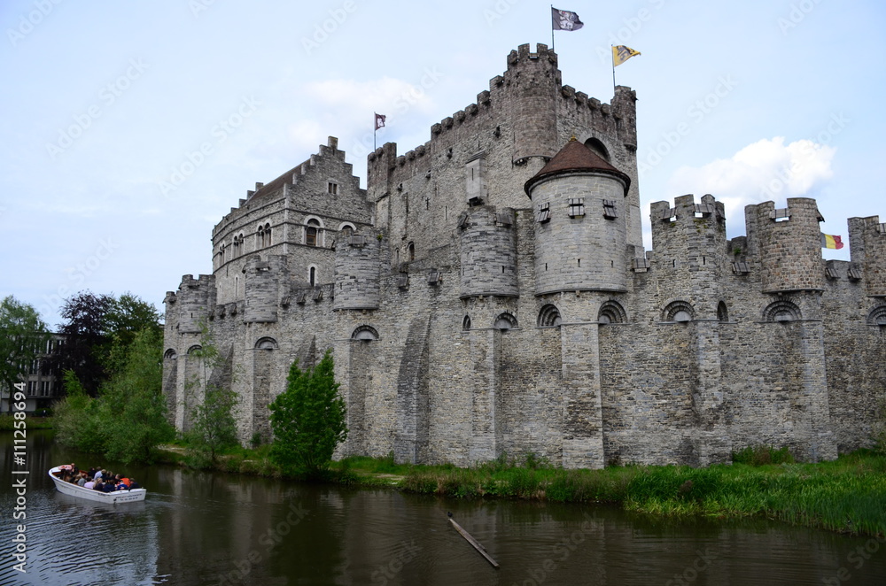 Tourists enjoying the view on the castle Gravensteen in the picturesque city of Gent in Belgium.