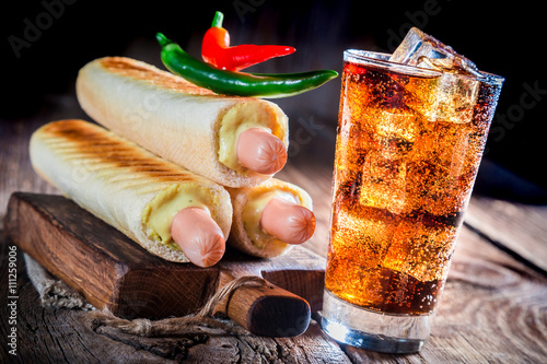 Closeup of grilled hot dog with cold drink