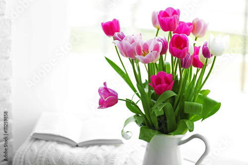 Beautiful fresh tulips on windowsill background