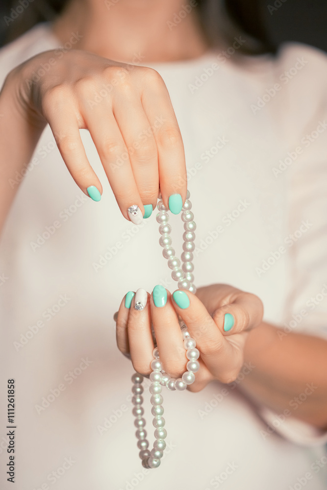 Beauty female fingernails with turquoise and white french diamonds manicure and pearl Beauty female fingernails with turquoise and white french diamonds manicure and pearl