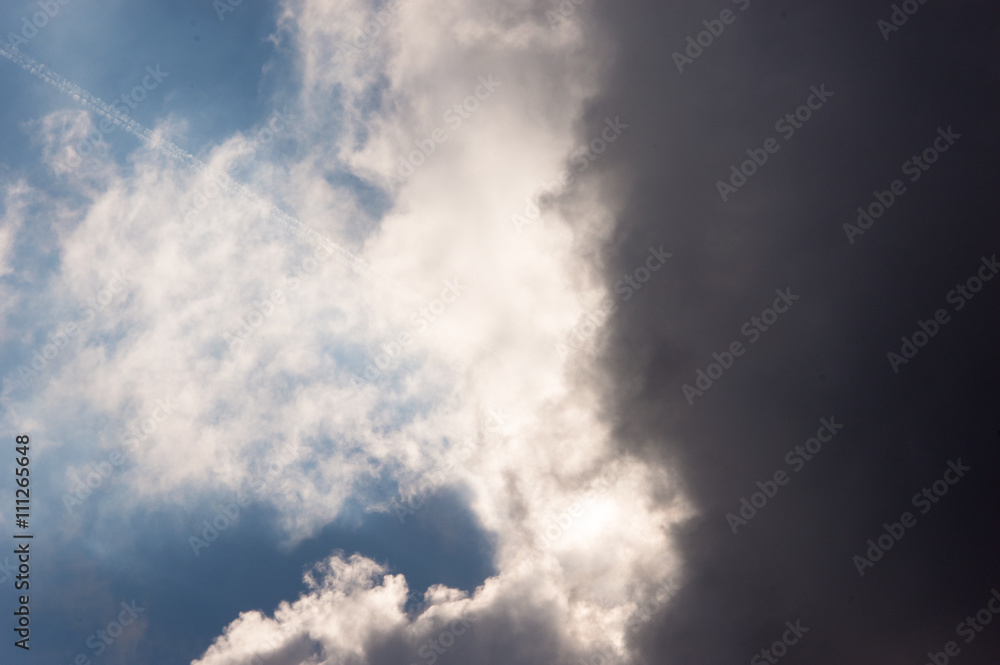 Dark storm clouds moving in from the right on the sun and a dark blue sky Dark storm clouds moving in from the right on the sun and a dark blue sky