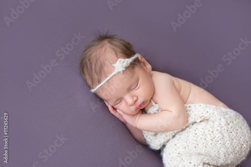 sleeping newborn baby on a purple blanket
