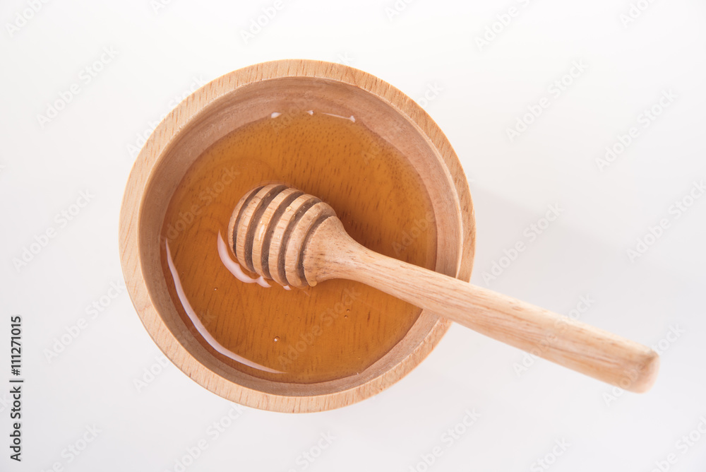 wooden honey dipper in honey bowl