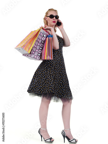 pretty blonde female with shopping bags talking on a cellphone.