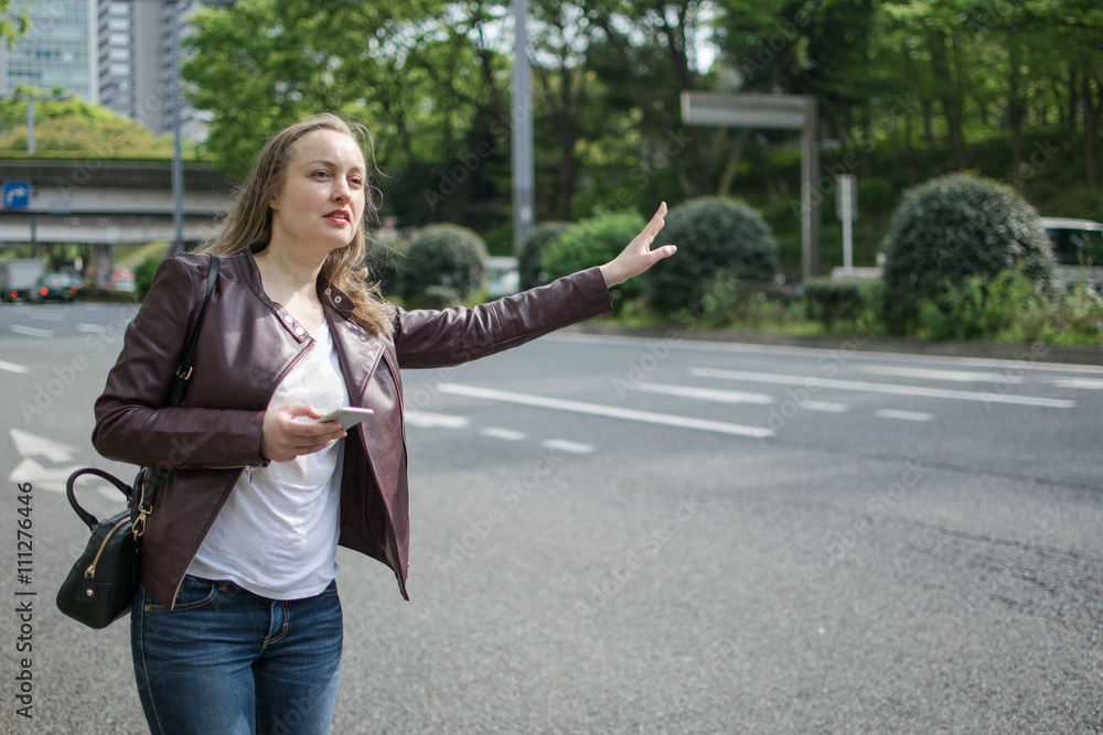 Fototapeta premium White Female Trying To Hail Taxi