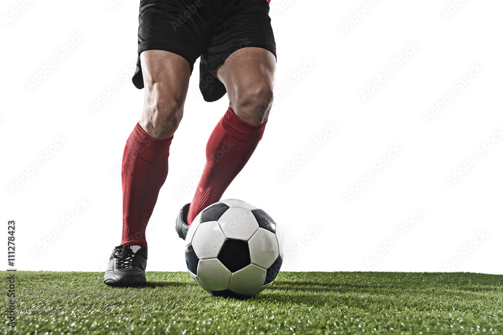 Obraz premium football player in red socks and black shoes running and dribbling with the ball playing on grass