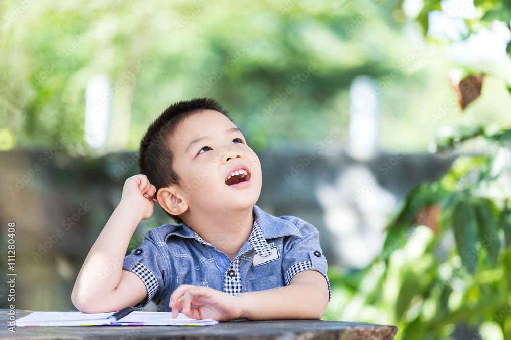 Little asian boy thinking and looks up