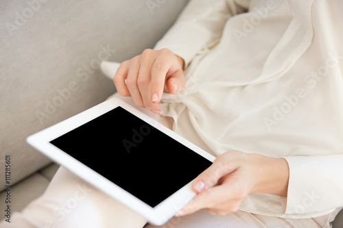 Cropped portrait of female hands holding digital tablet with copy space blank screen for your text or promotional content. Business woman or university student girl browsing internet via touch pad