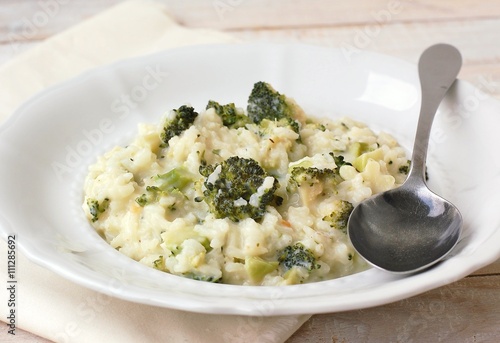 Creamy risotto with broccoli on the cloth and wooden background