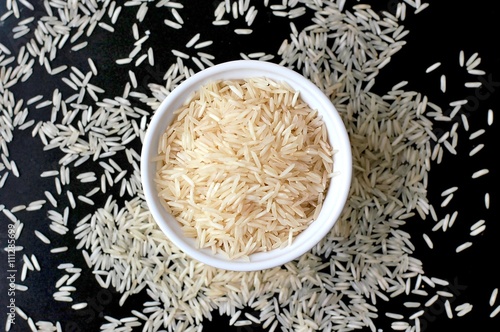 Картината върху платно Basmati rice in the bowl on the black background