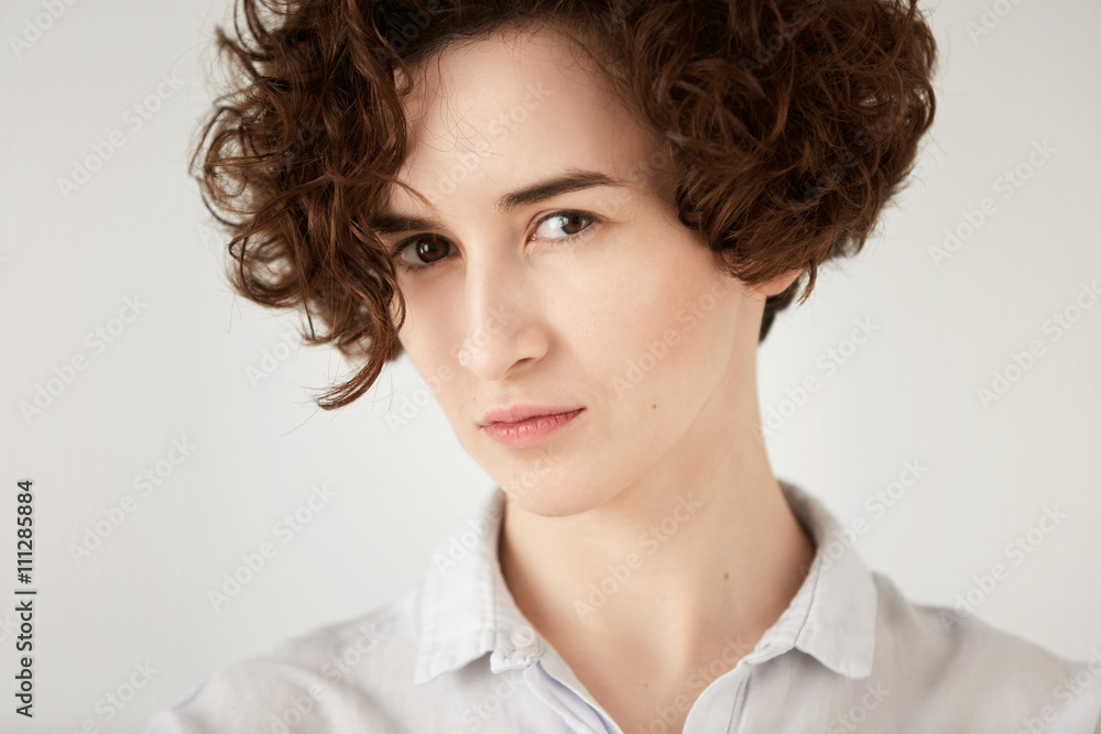 Close up studio portrait of young displeased or angry woman looking in annoyance. Isolated headshot of irritated girl with short curly red hair white hipster shirt. Human face expressions and emotions Close up studio portrait of young displeased or angry woman looking in annoyance. Isolated headshot of irritated girl with short curly red hair white hipster shirt. Human face expressions and emotions