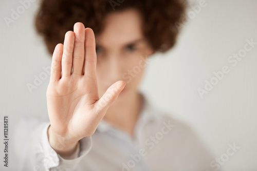 Close up isolated shot of woman with short brunette hair making stop gesture with her hand. Female entrepreneur showing stop sign, not wanting to continue business talks. Selective focus on the hand