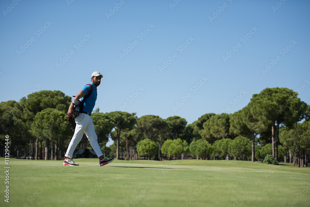 golf player walking and carrying bag