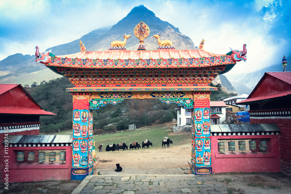 Gate Tengboche monastery in Nepal with the sacred wheel of Dharma and deer on them - obrazy, fototapety, plakaty 