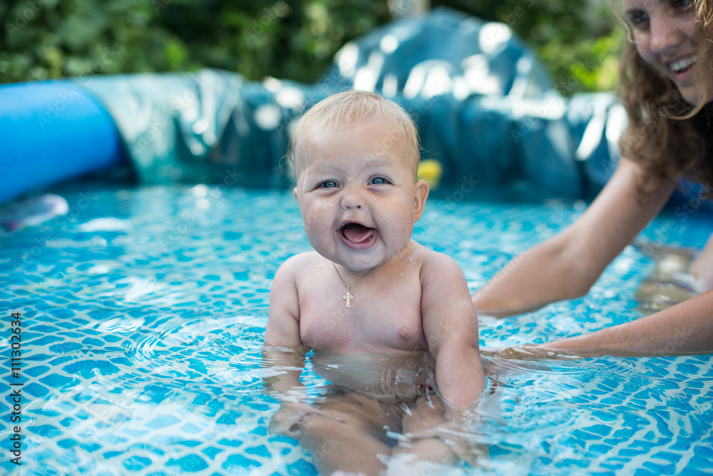 A cute happy young female girl child baby relaxing on the side of a swimming pool A cute happy young female girl child baby relaxing on the side of a swimming pool