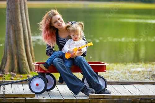 mother and daughter playing toy guitar in a lake photo