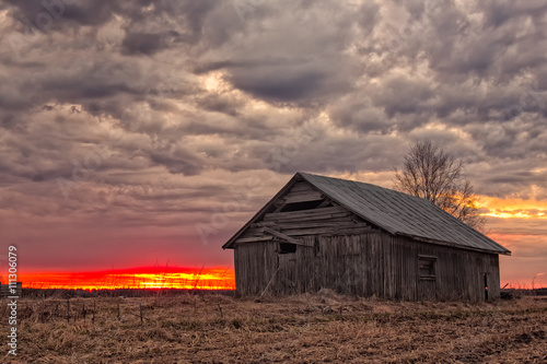 Sun Sets Behind An Old Barn House © k009034