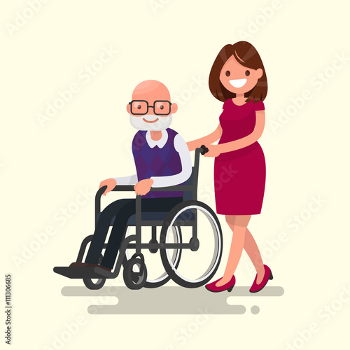 Social worker on a walk with disabled grandfather in a wheelchair