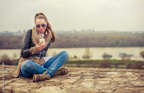 Young woman using mobile on the fortress