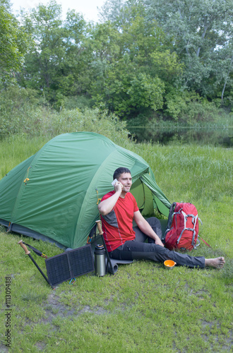 The man at the campsite in the woods .