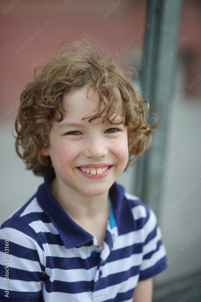 Cute little boy in a striped shirt is smiling cheerfully. Cute little boy in a striped shirt is smiling cheerfully.